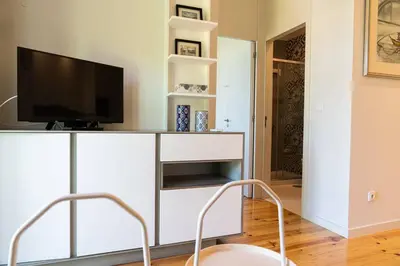 a living room with a tv on a white entertainment center at Casa Nina in Porto