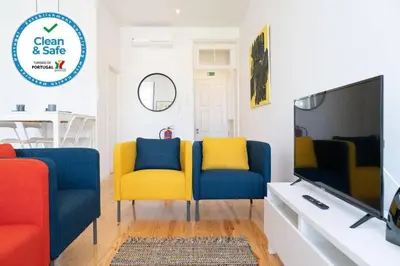 a living room with blue and yellow chairs and a tv at Joy Porto in Porto