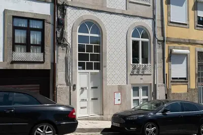 two cars parked in front of a building with white doors at Joy Porto in Porto
