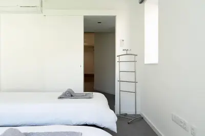 a bedroom with a white bed and a ladder at Joy Porto in Porto