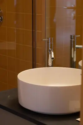 a white sink on a counter in a bathroom at Na Travessa Suítes in Porto