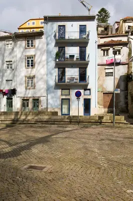 a white building with a blue sign in front of it at Miragaia Rio in Porto