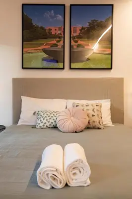 a bed with two towels on it with three pictures at Lemago Porto Apartments - Poveiros in Porto
