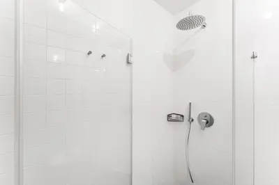 a white bathroom with a shower with a shower at GuestReady - Bourse Apartments in Porto