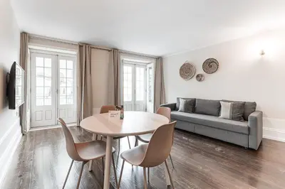 a living room with a table and chairs and a couch at GuestReady - Bourse Apartments in Porto