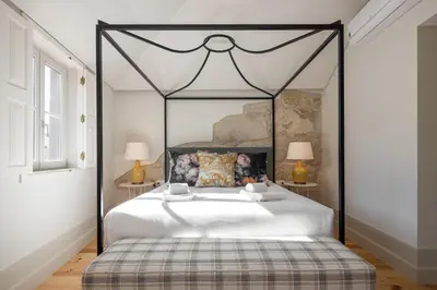 a bedroom with a large white bed with a black frame at Líbere Porto Laranjais in Porto
