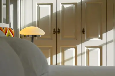 a white table with a lamp and a white closet at Líbere Porto Laranjais in Porto