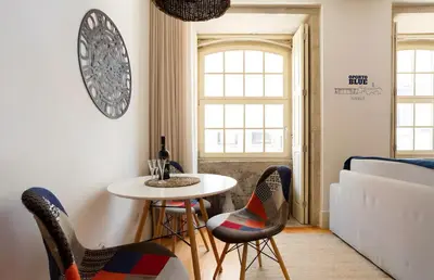 a room with a table and chairs and a bed at Oporto Blue Almada - Deluxe Citycenter Flat in Porto