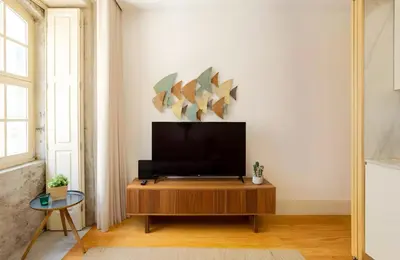 a living room with a flat screen tv on a wooden table at Oporto Blue Almada - Deluxe Citycenter Flat in Porto