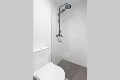 a bathroom with a shower with a toilet and a shower head at Oporto Sao Lazaro Apartment in Porto