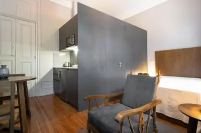 a living room with a chair and a kitchen at Oporto Sao Lazaro Apartment in Porto