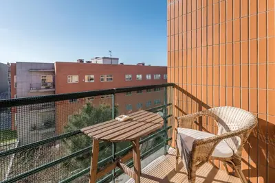 a wooden table and a chair on a balcony at GuestReady - Candal Big Watch in Vila Nova de Gaia
