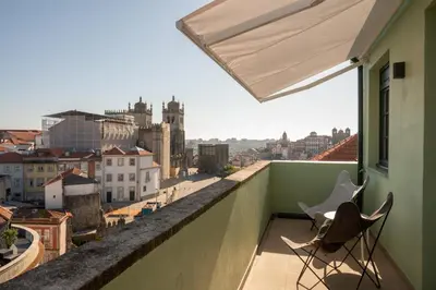 a balcony with two chairs and a view of a city at The Cathedral's Terrace in Porto