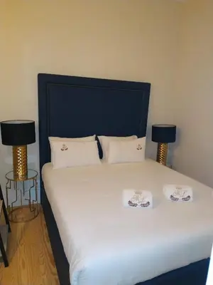 a bed with two pillows and two lamps on it at ML Apartments Almada Living in Porto