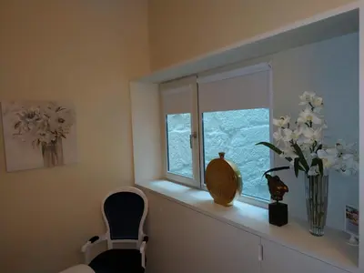 a window sill with a vase of flowers and a chair at ML Apartments Almada Living in Porto