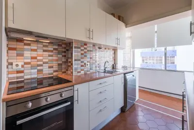 a kitchen with white cabinets and a sink at GuestReady - Urban escape in Porto in Porto