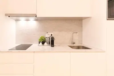 a kitchen with white cabinets and a sink at HM – Oporto Downtown Swimming Pool Apartment in Porto