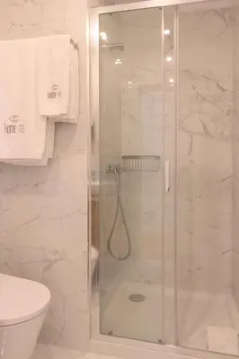 a shower with a glass door in a bathroom at HM – Oporto Downtown Swimming Pool Apartment in Porto