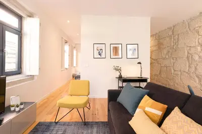 a living room with a couch and a chair at HM – Oporto Downtown Swimming Pool Apartment in Porto
