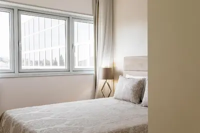 a white bedroom with a bed and a window at Casa D'Ouro Apartment by Oporto Soul in Porto