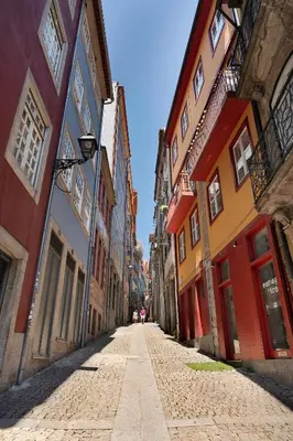 an empty street in a city with colorful buildings at Ribeira Trendy Flat in Medieval Mercadores Street in Porto
