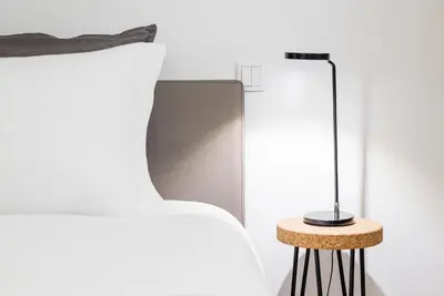 a lamp sitting on a table next to a bed at GuestReady - Tigerlily in Porto