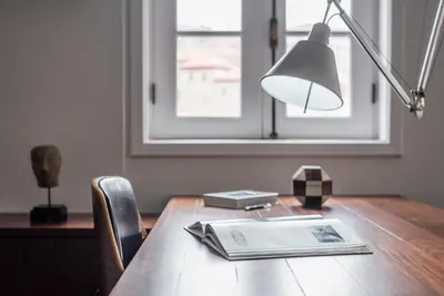 a desk with a lamp and a book on it at GuestReady - Subzero Design in Porto