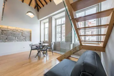 a living room with a staircase and a table at GuestReady - RiverWood Mezz in Porto