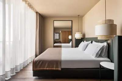a bedroom with a large bed and a mirror at Exe Essenzia Porto in Porto