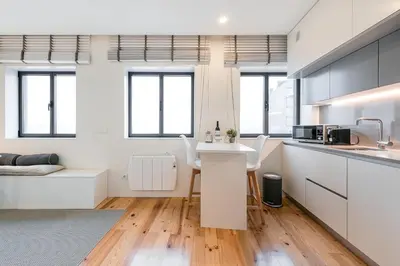 a kitchen with white cabinets and a counter top at GuestReady - Lazaro Studio in Porto