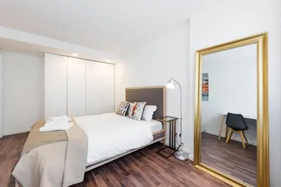 a bedroom with a white bed and a mirror at GuestReady - Square Painted Ceuta in Porto