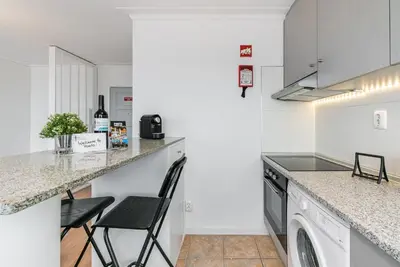 a kitchen with a counter and a washer and dryer at GuestReady - Porto Fantastic View in Vila Nova de Gaia