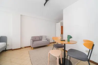 a living room with a table and chairs and a couch at Nomad's Easy Stay - 1BED Sunrise Cedofeita in Porto