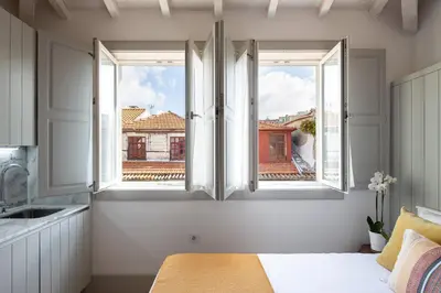 a kitchen with two windows and a bed in a room at CASA JOY Cathedral apartment in Porto