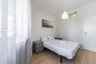 a white bedroom with a bed and a window at GuestReady - Music Area in Porto