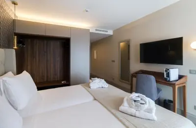 a hotel room with a bed and a desk at Oca Oriental Porto Hotel in Porto