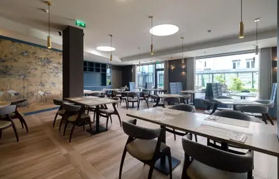 a restaurant with tables and chairs and windows at Oca Oriental Porto Hotel in Porto