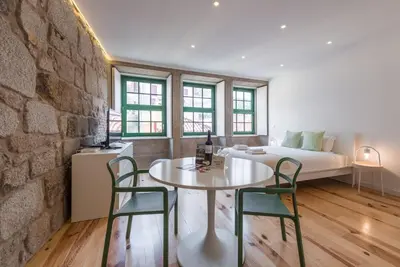 a room with a table and chairs and a bed at GuestReady - Mezuzah Yellow in Porto