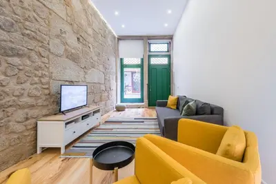 a living room with a couch and a tv at GuestReady - Mezuzah Green in Porto