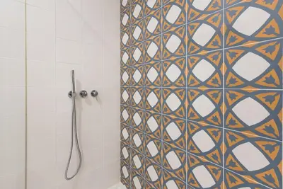 a shower with a mosaic tile wall in a bathroom at GuestReady - Mezuzah Green in Porto