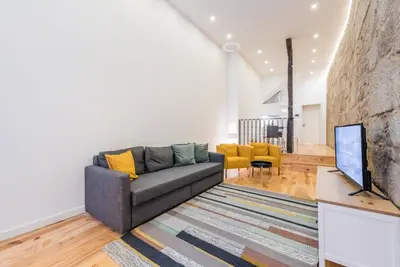 a living room with a couch and a tv at GuestReady - Mezuzah Green in Porto