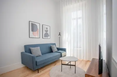 a living room with a blue couch and a table at Liiiving in Porto - City View Apartments in Porto