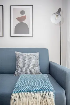 a blue couch with a pillow and a lamp at Liiiving in Porto - City View Apartments in Porto