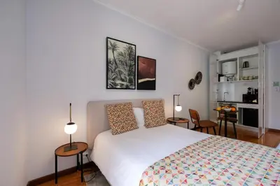 a bedroom with a bed and two tables and two lamps at Impar Studios Deluxe in Porto