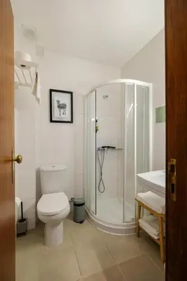 a bathroom with a shower and a toilet and a sink at Impar Studios Deluxe in Porto
