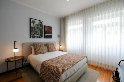 a bedroom with a bed and a large window at Impar Studios Deluxe in Porto