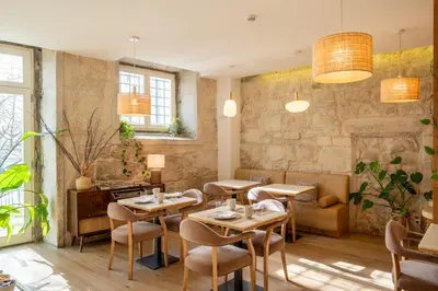 a restaurant with tables and chairs in a room at Memoria Porto FLH Hotels in Porto