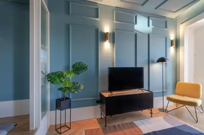 a living room with a tv and a chair at HM - Infante Riverside Apartment N in Porto