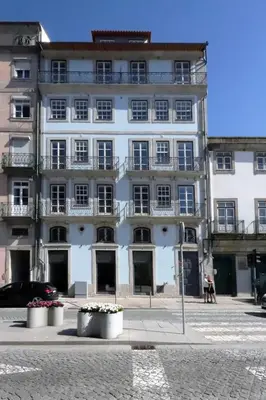 a large white building with windows on a street at HM - Infante Riverside Apartment N in Porto