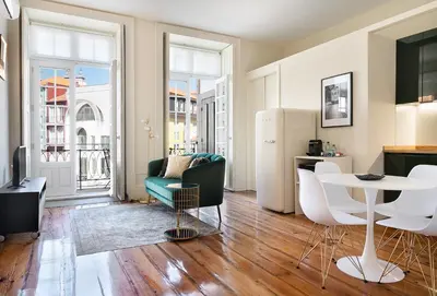 a living room with a table and a refrigerator at Historic apartment at Cardosas with balcony in Porto